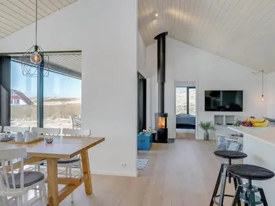 a dining room and living room with a table and chairs at Holiday Home Aiko - 50m from the sea by Interhome in Torsted