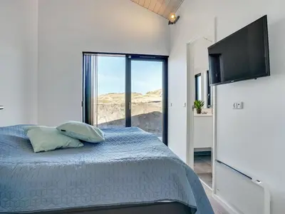 a bedroom with a bed and a large window at Holiday Home Aiko - 50m from the sea by Interhome in Torsted