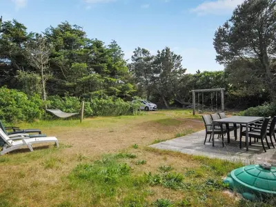 a picnic table and chairs in a park at Holiday Home Konrad - 400m from the sea by Interhome in Torsted