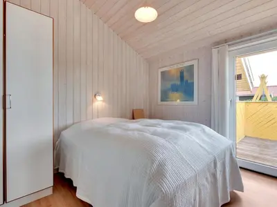 a bedroom with a white bed and a window at Holiday Home Ritte - 200m from the sea by Interhome in Torsted