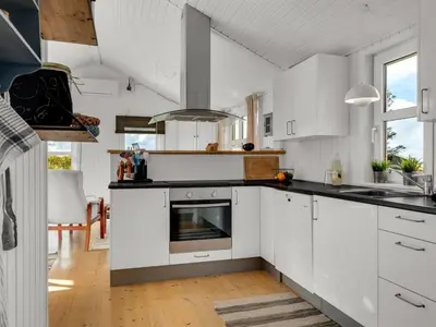a kitchen with white cabinets and a stove at Holiday Home Adisl - 350m from the sea by Interhome in Torsted