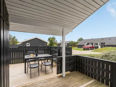 a patio with a table and chairs on a wooden deck at Holiday Home Mads - 950m from the sea by Interhome in Torsted