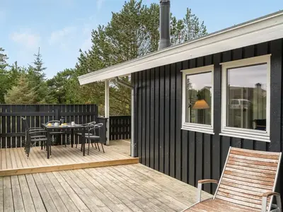 a deck with a table and chairs on a house at Holiday Home Mads - 950m from the sea by Interhome in Torsted