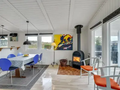 a dining room with a table and chairs and a fireplace at Holiday Home Mads - 950m from the sea by Interhome in Torsted