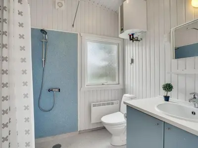 a bathroom with a shower and a toilet and a sink at Holiday Home Mads - 950m from the sea by Interhome in Torsted