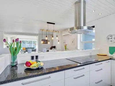a kitchen with white cabinets and a bowl of fruit on a counter at Holiday Home Örjan - 400m from the sea by Interhome in Torsted