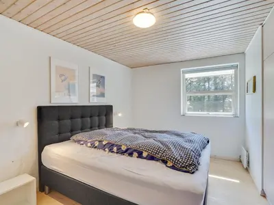 a bedroom with a bed with a black headboard and a window at Holiday Home Örjan - 400m from the sea by Interhome in Torsted
