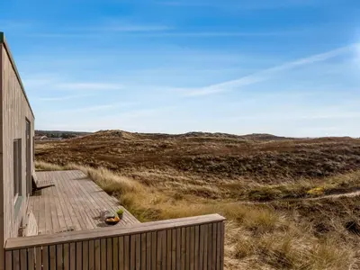 a wooden deck on the side of a house at Holiday Home Ginne - 125m from the sea by Interhome in Torsted