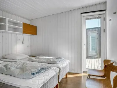 a bedroom with two beds and a window at Holiday Home Ginne - 125m from the sea by Interhome in Torsted