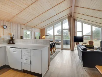 a kitchen and living room with a couch and windows at Holiday Home Rosali - 500m from the sea by Interhome in Torsted