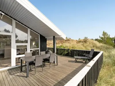 a deck with a table and chairs on a house at Holiday Home Rosali - 500m from the sea by Interhome in Torsted