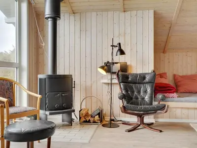 a living room with a chair and a stove at Holiday Home Rosali - 500m from the sea by Interhome in Torsted