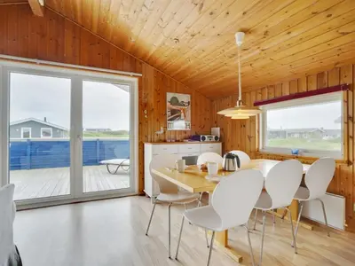 a kitchen and dining room with a table and chairs at Holiday Home Joern - 300m from the sea by Interhome in Torsted