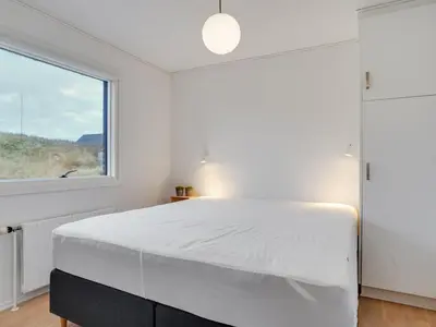 a bedroom with a white bed and a window at Holiday Home Fridolina - 200m from the sea by Interhome in Torsted