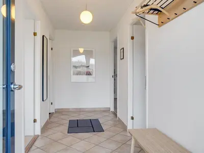 a hallway with white walls and a stairway with a door at Holiday Home Fridolina - 200m from the sea by Interhome in Torsted