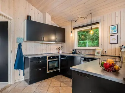 a kitchen with black cabinets and a bowl of fruit on the counter at Holiday Home Ansfried - 900m from the sea by Interhome in Torsted