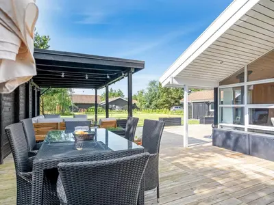 a patio with a table and chairs on a deck at Holiday Home Ansfried - 900m from the sea by Interhome in Torsted