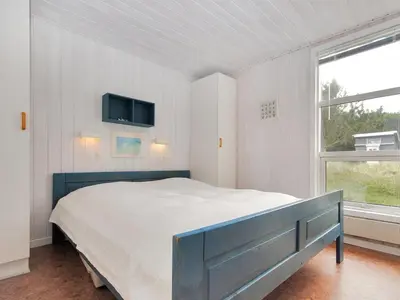 a bedroom with a bed and a tv on the wall at Holiday Home Dode - 225m from the sea by Interhome in Torsted