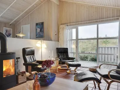 a living room with two chairs and a fireplace at Holiday Home Tino - 900m from the sea by Interhome in Torsted
