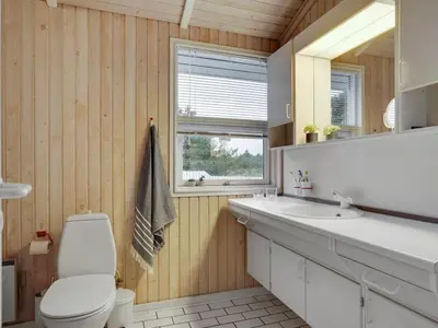 a bathroom with a toilet and a sink and a mirror at Holiday Home Tino - 900m from the sea by Interhome in Torsted