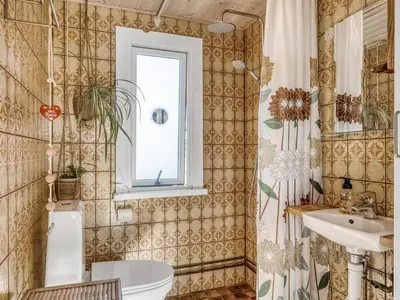 a bathroom with a toilet and a sink and a window at Holiday Home Letta - 800m from the sea by Interhome in Torsted