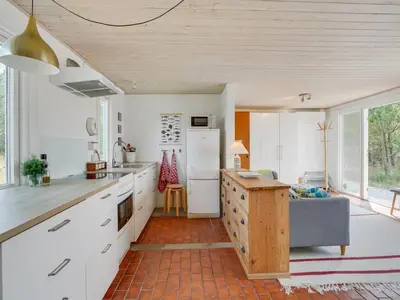 a kitchen with white cabinets and a refrigerator at Holiday Home Letta - 800m from the sea by Interhome in Torsted