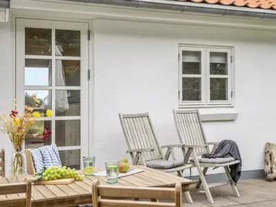 a patio with three chairs and a table with a bowl of fruit at Holiday Home Meindor - 350m from the sea by Interhome in Torsted