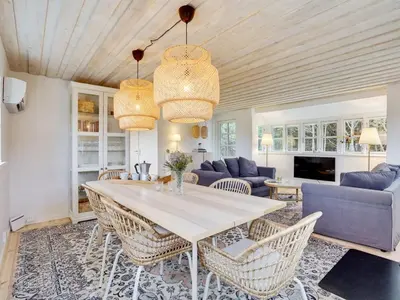 a living room with a table and chairs at Holiday Home Meindor - 350m from the sea by Interhome in Torsted