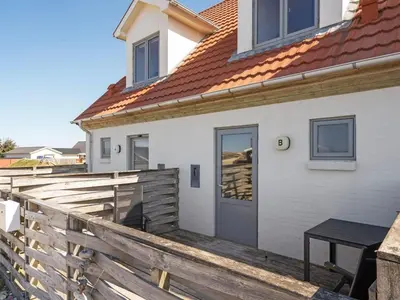 a white house with a wooden fence and a door at Apartment Nermin - 300m from the sea by Interhome in Torsted