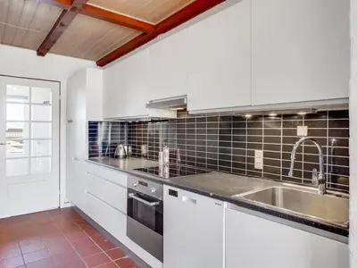 a kitchen with white cabinets and a sink at Apartment Nermin - 300m from the sea by Interhome in Torsted