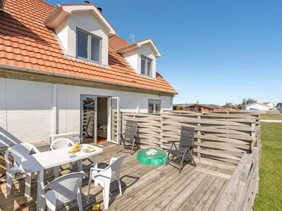 a patio with a table and chairs on a wooden deck at Apartment Nermin - 300m from the sea by Interhome in Torsted