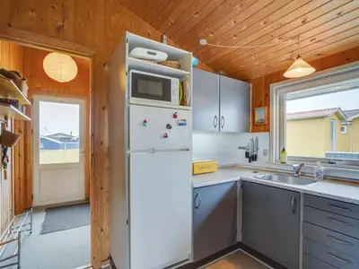 a white refrigerator in a kitchen with a window at Holiday Home Svea - 400m from the sea by Interhome in Torsted
