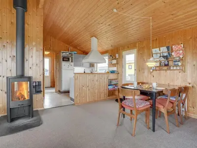 a kitchen with a stove and a table and chairs at Holiday Home Svea - 400m from the sea by Interhome in Torsted