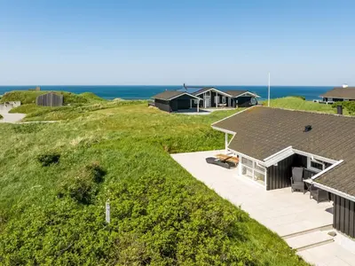 an aerial view of a house with the ocean in the background at Holiday Home Abel - 350m from the sea by Interhome in Løkken