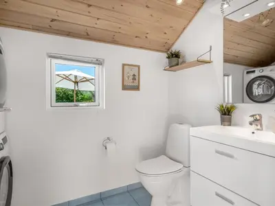 a white bathroom with a toilet and a window at Holiday Home Federica - 500m from the sea by Interhome in Løkken