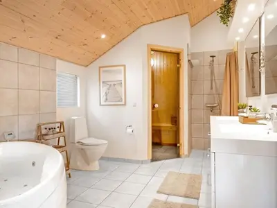 a bathroom with a tub and a toilet and a sink at Holiday Home Federica - 500m from the sea by Interhome in Løkken