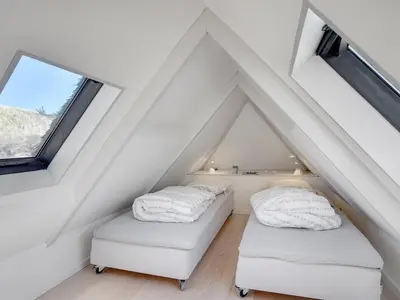 two beds in the attic with white ceilings at Holiday Home Tabea - 150m from the sea by Interhome in Løkken