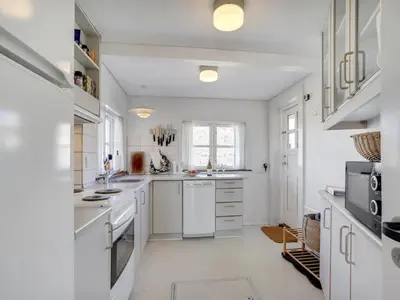 a white kitchen with white appliances and a window at Holiday Home Tabea - 150m from the sea by Interhome in Løkken