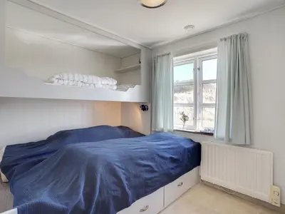 a bedroom with a bed with a blue blanket at Holiday Home Tabea - 150m from the sea by Interhome in Løkken