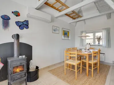 a living room with a wood stove and a table at Holiday Home Tabea - 150m from the sea by Interhome in Løkken
