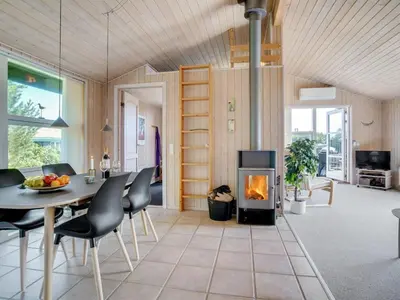 a living room with a table and a fireplace at Holiday Home Elsabet - 750m from the sea by Interhome in Løkken