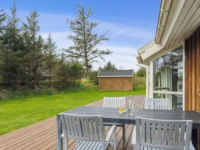 a patio with a table and chairs on a deck at Holiday Home Aleta - 500m from the sea by Interhome in Løkken