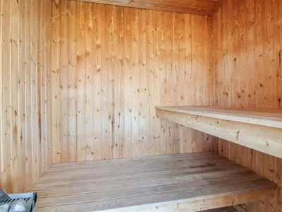a wooden interior of a sauna with a wooden shelf at Holiday Home Falka - 800m from the sea by Interhome in Løkken