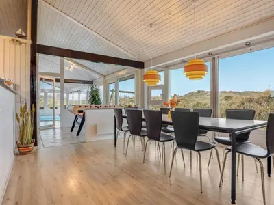 a dining room with a table and chairs at Holiday Home Falka - 800m from the sea by Interhome in Løkken