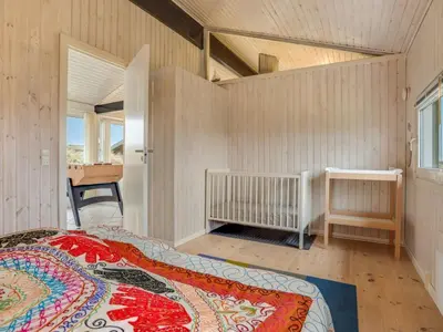 a bedroom with a bed in a room with a window at Holiday Home Falka - 800m from the sea by Interhome in Løkken
