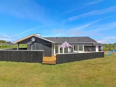 a house with a fence in front of a yard at Holiday Home Dome - 750m from the sea by Interhome in Løkken