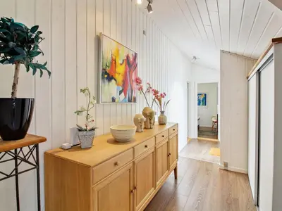 a room with a wooden cabinet with vases on it at Holiday Home Annalisa - 1-2km from the sea by Interhome in Løkken