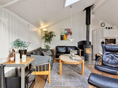 a living room with leather furniture and a fireplace at Holiday Home Annalisa - 1-2km from the sea by Interhome in Løkken