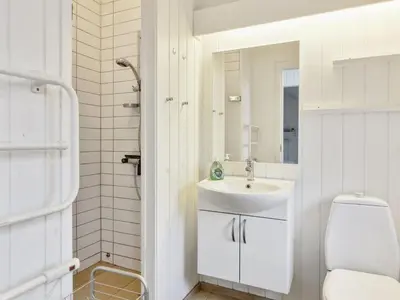 a white bathroom with a sink and a toilet at Holiday Home Annalisa - 1-2km from the sea by Interhome in Løkken