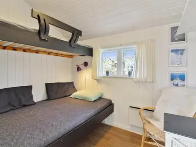 a small bedroom with a bed and a window at Holiday Home Annalisa - 1-2km from the sea by Interhome in Løkken